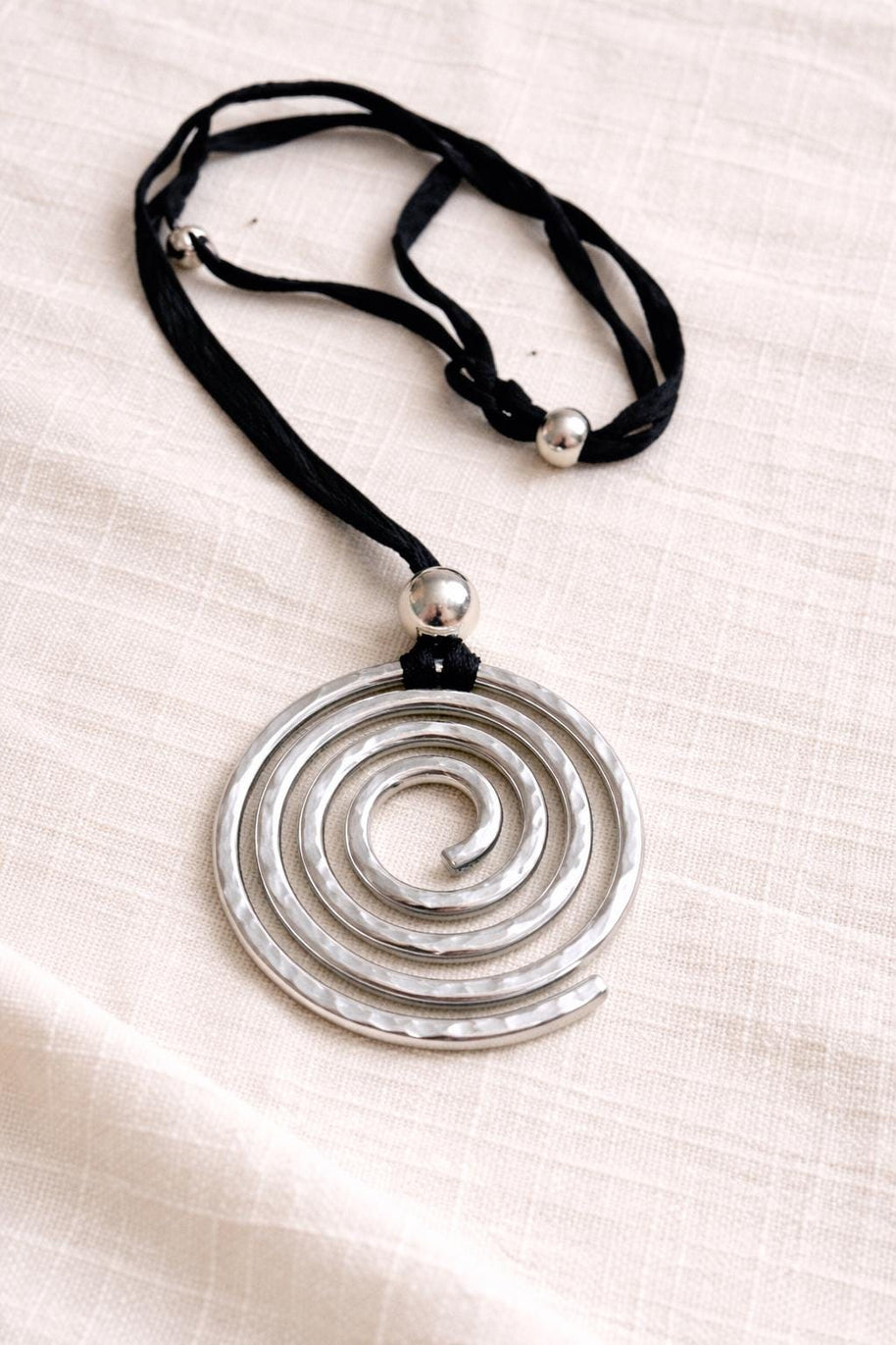 Collana spirale argento martellato su cordino nero regolabile | Ciondolo statement moderno Urban Ritual | Gioiello donna minimal contemporan